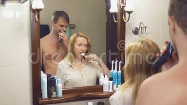 美丽的夫妻，男人和女人，一起在镜子前的浴室里洗。 4K，慢动作，女人是