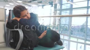 疲惫的少女少年旅行者睡<strong>在机场</strong>，等待飞机起飞，登机口的长椅上，她的行李都<strong>在</strong>她身边
