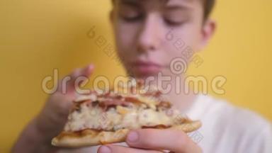 快乐的小男孩吃一片披萨的概念。 少年男孩饿了吃一片生活方式披萨。 慢速视频