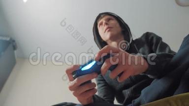 男孩少年在引擎盖上玩电子游戏的控制台上的游戏。 青少年穿戴帽衫