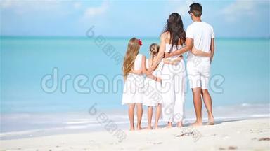 白色海滩上幸福美丽的家庭