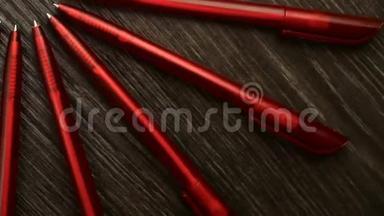 许多红色的钢笔在<strong>黑色</strong>的木制背景上围成一个圆圈。 概念办或学校，知识日，<strong>九月</strong>一日..