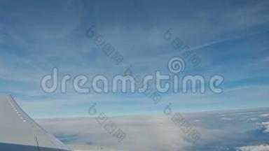 从飞机上看，飞机的机翼在蓝天的云层上飞行。