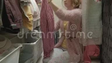 一个漂亮的女孩微笑着，在更衣室的篮子里整理和折叠衣服。 把东西整理好