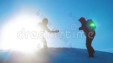 团队合作游客冬季雪商务旅行提供了帮助。 两个男人的生活方式和背包徒步旅行帮助