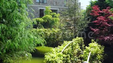 奢华的维多利亚风格酒店，沉浸在美丽的树木和灌木丛中。 屋顶有尖顶，背景清澈
