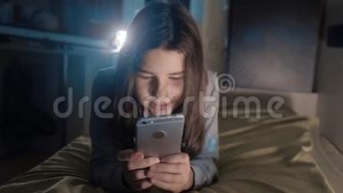 十几岁的<strong>女孩</strong>网上<strong>购物</strong>在床上看她的智能手机。 一个<strong>小女孩</strong>写了一条信息