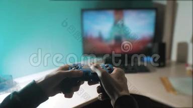 男孩正在玩控制器操纵杆Gamepad控制台电脑。 在电视上玩电子游戏机。 手握新手