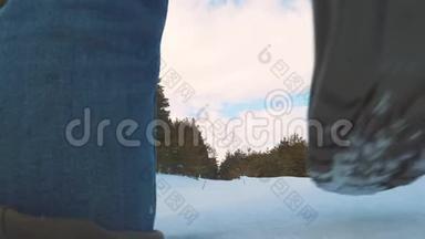 人的脚在深雪中行走。 慢动作视频。 带背包的人在雪林冬天散步。 克服困难