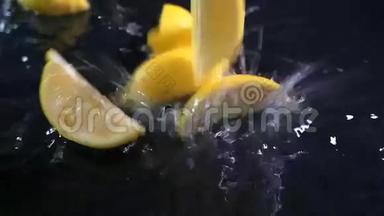 缓慢运动的柠檬在黑色表面上<strong>落下水滴</strong>。