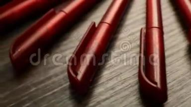 许多<strong>红色</strong>的钢笔在黑色的木制背景上围成一个<strong>圆圈</strong>。 概念办或学校，知识日，九月一日..