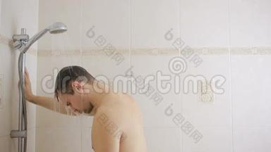 男人在淋浴时用洗发<strong>水</strong>洗头。 浴室。