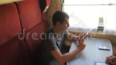 休闲男子阅读手机生活方式手机屏幕，同时阅读短信旅行列车。 慢动作