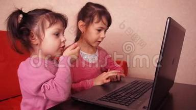 孩子们在<strong>笔记本</strong>电脑里玩。 两个小女孩印在<strong>笔记本</strong>电脑上。 两个姐姐坐在橙色的沙发上看着一圈
