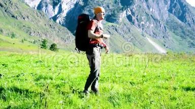 徒步旅行者带着背包在绿色的山地<strong>草地</strong>上<strong>行走</strong>。 夏季运动和娱乐理念。