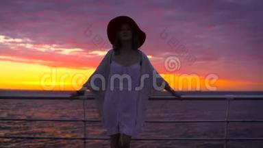 美丽的日落时分，穿着白色连衣裙和戴着帽子的年轻迷人女子在海上背景<strong>下摆</strong>姿势