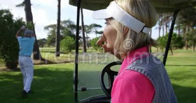 快乐的<strong>女</strong>高尔夫球手坐在高尔夫球车上
