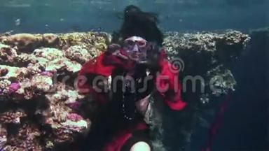 年轻女孩模特自由潜水员水下穿着红海海盗的红色服装。
