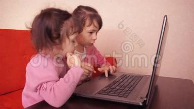 孩子们在笔记本<strong>电脑</strong>里玩。 <strong>两个</strong>小女孩印在笔记本<strong>电脑</strong>上。 <strong>两个</strong>姐姐坐在橙色的沙发上看着一圈