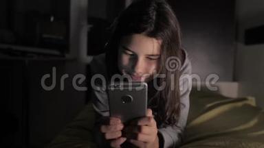 十几岁的<strong>女孩</strong>网上<strong>购物</strong>在床上看智能手机。 一个<strong>小女孩</strong>写了一条信息