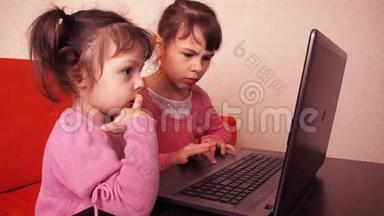 孩子们在<strong>笔记本</strong>电脑里玩。 两个小女孩印在<strong>笔记本</strong>电脑上。 两个姐姐坐在橙色的沙发上看着一圈