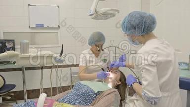 牙医诊所的妇女得到牙科治疗，以填补牙齿的空洞。 牙科修复和复合材料