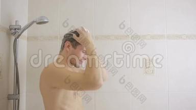 男人在淋浴时用洗发水洗头。 浴室。