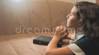 小女孩在夜里祈祷。 小女孩用手祈祷。 小女孩圣经在她的生活方式中祈祷圣经