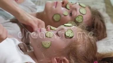 一个女人和她的女儿在家里取笑黄瓜面具