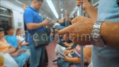 休闲男子从手机智能手机屏幕<strong>上</strong>阅读，同时看导航员在<strong>地铁上</strong>旅行。 慢慢慢慢