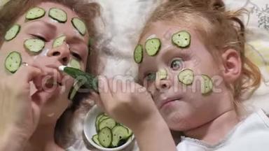 一个女人和她的女儿在家里取笑黄瓜面具