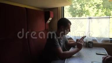 火车车厢上的人的剪影听着耳机上的音乐在信使社交媒体上留言