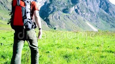 徒步旅行者带着背包在绿色的山地<strong>草地</strong>上<strong>行走</strong>。 夏季运动和娱乐理念。