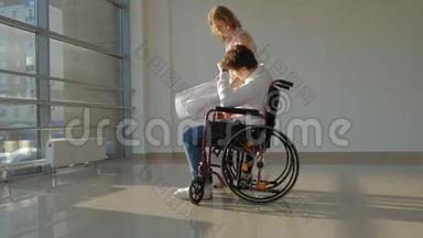 一位坐在轮椅上的残疾商人在窗户上，一张大纸上写着一张照片，与一位同事讨论工作