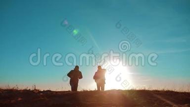 团队合作。 两名游客徒步旅行，男人和狗带着背包在日落时去徒步旅行。 慢动作视频。 旅行和徒步旅行