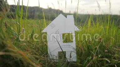 幸福家庭生活方式建设民宿理念.. 纸房子矗立在大自然的绿草中。 象征生命生态