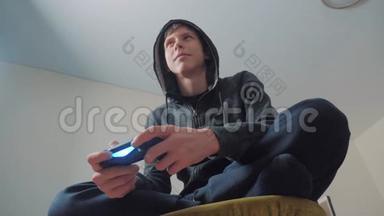男孩少年在引擎盖上玩电子游戏的控制台上的游戏。 青少年穿着头罩毛衣