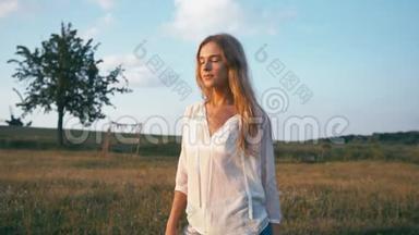 美丽的微笑女孩在春天的田野上。 草甸。 笑着快乐的年轻女模特健康<strong>长寿</strong>的肖像