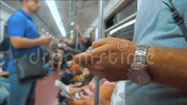 休闲男子从手机智能手机屏幕上阅读，同时看着地铁里的领航员