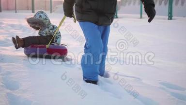 一个快乐的孩子在雪管里骑着雪慢动作。 冬天的雪景。 户外运动