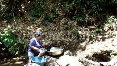 菲律宾农村<strong>社区</strong>缺乏公共供水系统<strong>设施</strong>，迫使这名妇女即使在污染的河流中也要洗衣服。