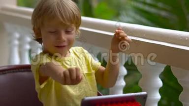 热带地区的男孩用平板电脑和无线耳机通过视频通话与<strong>朋友</strong>和<strong>家人</strong>交谈