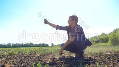 男人农民手里握着新鲜的土壤。 慢动作视频。 大地的泥土使大地保持着春天的象征