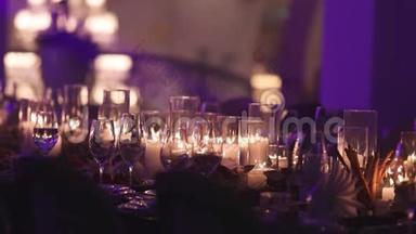 餐桌上的装饰蜡烛，桌子上的眼镜和圣诞蜡烛，带玻璃的白色蜡烛
