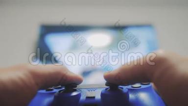 在电视上播放视频控制台。 手握新的操纵杆在电视上播放视频控制台。 玩家玩游戏游戏游戏和游戏记事本的生活方式