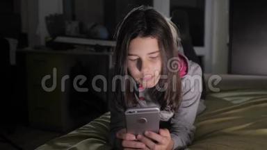 十几岁的女孩网上<strong>购物</strong>在床上看智能手机。 一个<strong>少女</strong>写生活方式