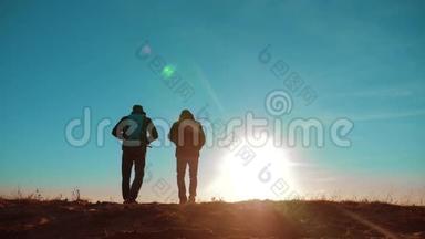 团队合作。 两名游客徒步<strong>旅行</strong>，男人和狗带着背包在日落时散步，<strong>去</strong>徒步<strong>旅行</strong>。 慢动作视频。 旅程