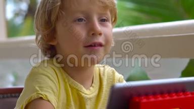 热带地区的男孩用平板电脑和无线耳机通过视频通话与朋友和家人交谈