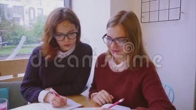 女大学生在咖啡馆学习，两个女朋友一起学习