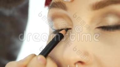 专业化妆师在眼部涂抹眼线。化妆与时尚理念